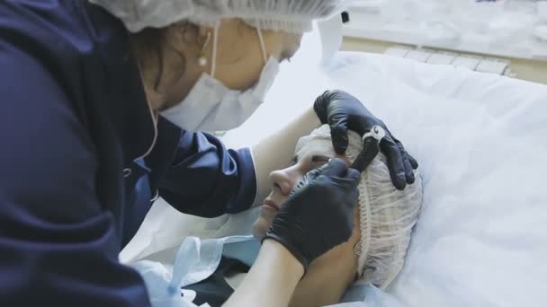 Una empleada de una clínica de cosmetología hace una rutina de microvoladura a una paciente femenina — Vídeo de stock