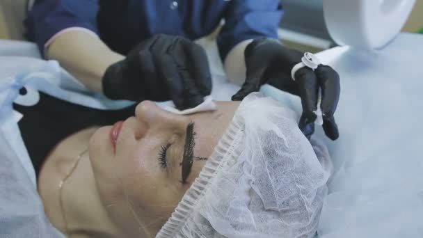 Eine Mitarbeiterin einer kosmetologischen Klinik macht einer Patientin eine Mikrostrahlung — Stockvideo