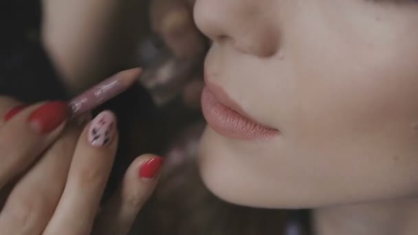 Визажист делает профессиональный макияж для очень красивой девушки в фотостудии — стоковое видео