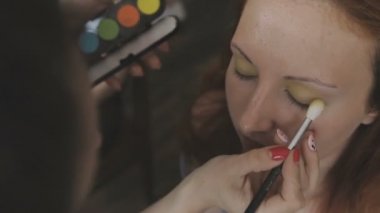 Çok güzel bir kız bir fotoğraf Studio için profesyonel makyaj makyaj sanatçısı yapar