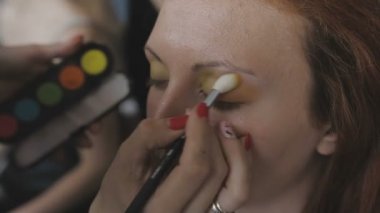 Çok güzel bir kız bir fotoğraf Studio için profesyonel makyaj makyaj sanatçısı yapar