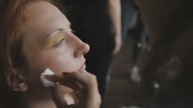 Çok güzel bir kız bir fotoğraf Studio için profesyonel makyaj makyaj sanatçısı yapar