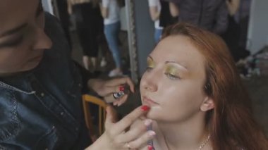 Çok güzel bir kız bir fotoğraf Studio için profesyonel makyaj makyaj sanatçısı yapar