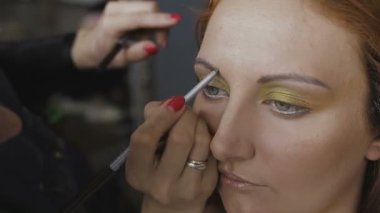 Çok güzel bir kız bir fotoğraf Studio için profesyonel makyaj makyaj sanatçısı yapar