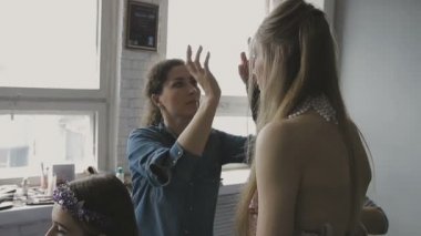 Çok güzel bir kız bir fotoğraf Studio için profesyonel makyaj makyaj sanatçısı yapar