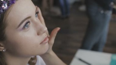 Çok güzel bir kız bir fotoğraf Studio için profesyonel makyaj makyaj sanatçısı yapar