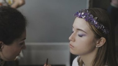 Çok güzel bir kız bir fotoğraf Studio için profesyonel makyaj makyaj sanatçısı yapar