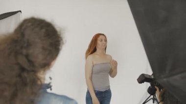 Çok güzel bir kız bir fotoğraf stüdyosu kamera önünde poz