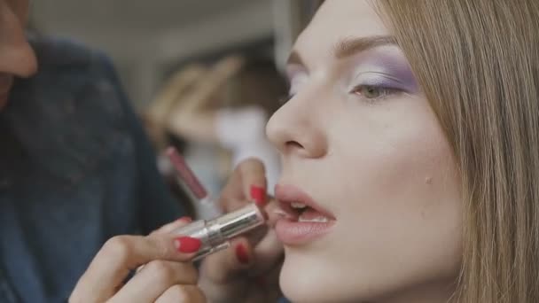 Maquillaje artista hace un maquillaje profesional para una chica muy hermosa en un estudio de fotografía — Vídeos de Stock