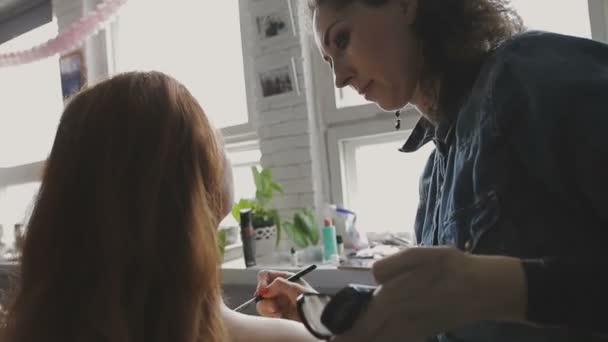 Vizážista je profesionální make-up pro velmi krásná dívka ve fotografickém studiu — Stock video