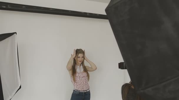 Heel mooi meisje poseren voor een camera in een fotostudio — Stockvideo