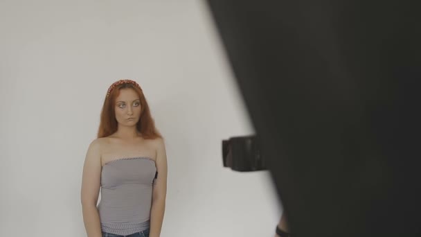 Πολύ όμορφη κοπέλα ποζάρει μπροστά από μια κάμερα σε ένα στούντιο φωτογραφίας — Αρχείο Βίντεο