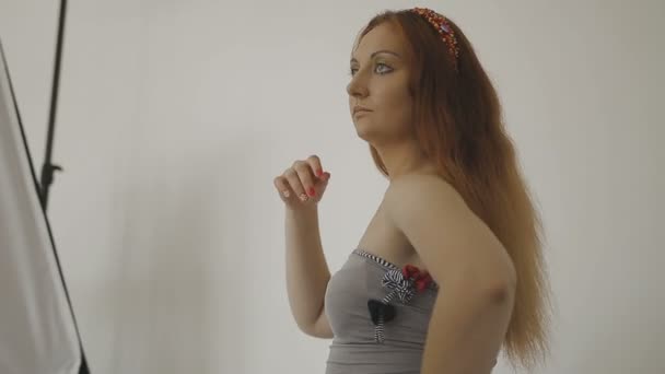 Mycket vacker flicka poserar framför en kamera i en fotostudio — Stockvideo