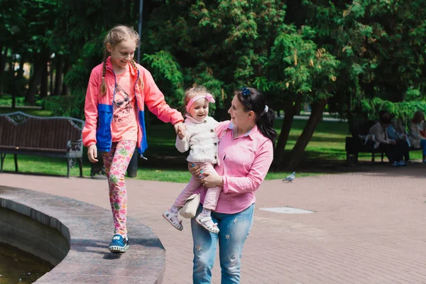 Дети прогуливаются в парке в выходной день. Солнце светит. — стоковое фото