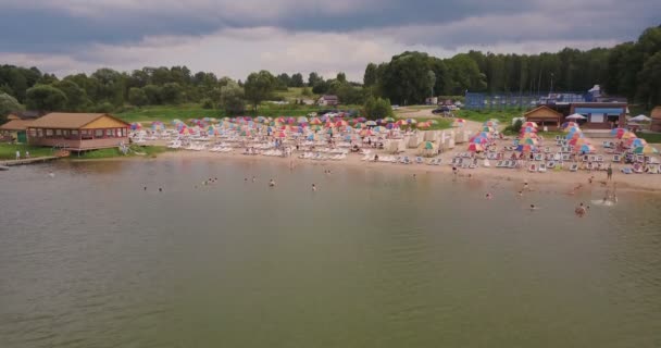 Політ над яскравим пляжем з різнокольоровими бунгало — стокове відео