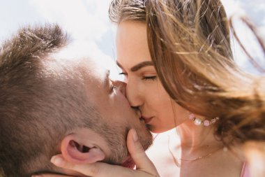 Genç çift, sarılma ve nehir kıyısında birbirlerine gülümsüyor. Kumlu sahilde yürüyüş