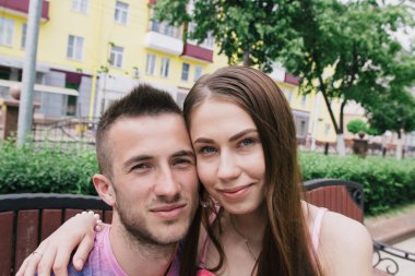 Güneşli bir günde bir alışveriş merkezi bir bankta oturan sevgi dolu çift