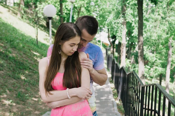 Jovem casal abraçando e sorrindo um para o outro no parque — Fotografia de Stock