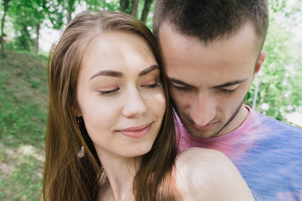 Mladý pár objímání a usmívá se na sebe v parku — Stock fotografie