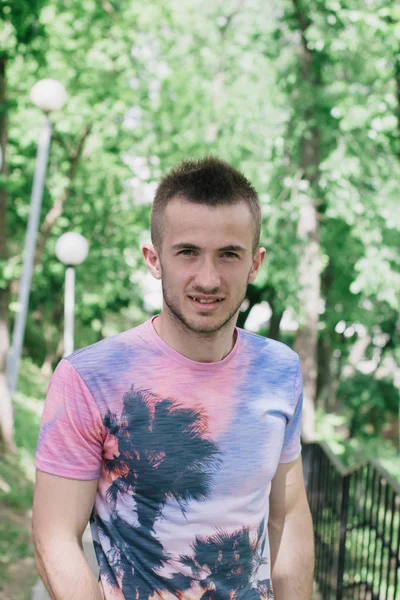 Retrato de um jovem bonito num dia ensolarado. Árvores verdes — Fotografia de Stock