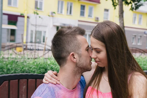 Pareja amorosa sentada en un banco en un centro comercial en un día soleado — Foto de Stock