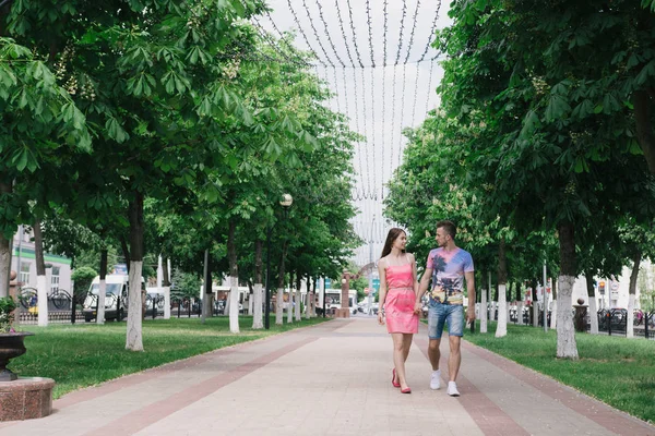 Un couple amoureux marche le long de l'avenue par une journée ensoleillée — Photo