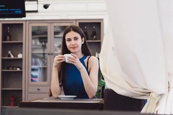 Очень красивая деловая женщина сидит в кафе и держит чашку кофе в руках — стоковое фото