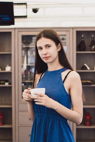 Une très belle femme d'affaires s'assoit dans un café et tient une tasse de café dans ses mains — Photo