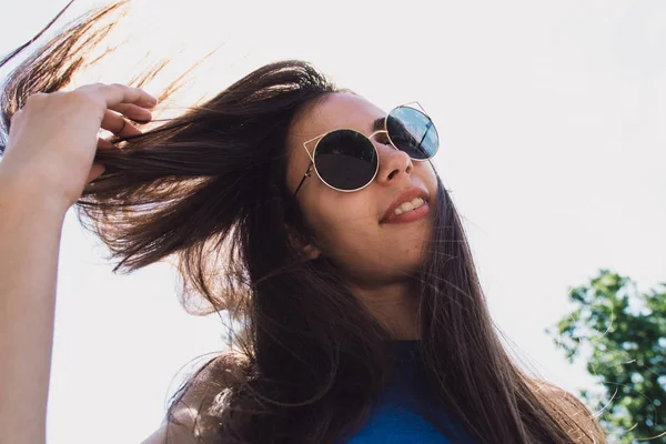 Çok güzel bir kız saçını sallayarak siyah gözlüklü