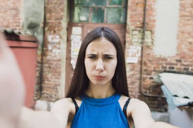 Çok güzel ve neşeli kız uzun, lüks saçlı sokakta duruyor ve bir selfie yapar