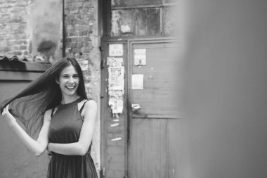 Çok güzel ve neşeli kız uzun, lüks saçlı sokakta duruyor