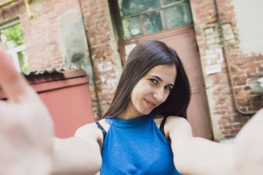 Çok güzel ve neşeli kız uzun, lüks saçlı sokakta duruyor ve bir selfie yapar