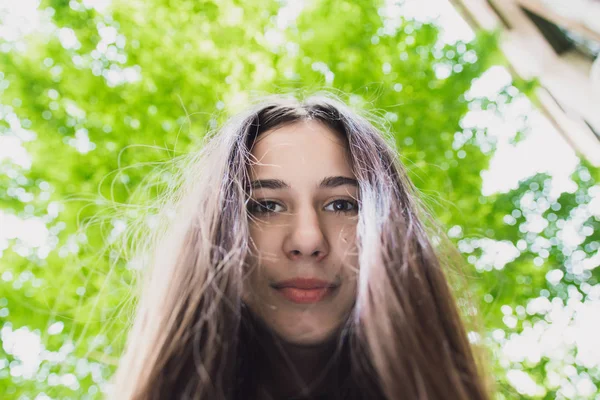 Une fille très belle et joyeuse se tient dans la rue avec de longs cheveux luxueux — Photo