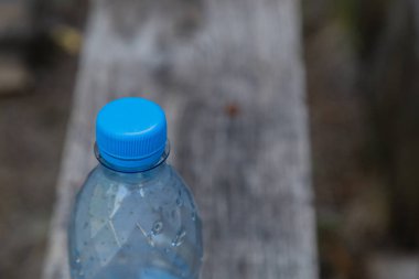 ahşap arka plan üzerinde su ile plastik şişe.