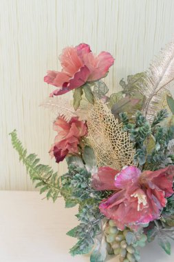 Pahalı bir komodinin üzerinde yapay çiçekler