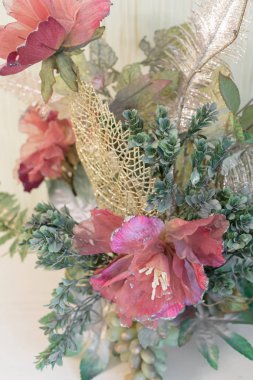 Pahalı bir komodinin üzerinde yapay çiçekler