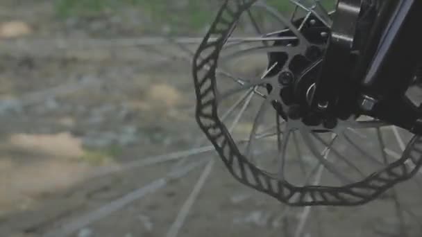 Spinning bicycle wheel against a brick wall in the background — Stock Video
