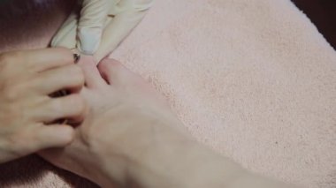 Bakım kız bacaklar pedikür, Lehçe, güzel ışıklar hakkında. Pedikür salonda. Asıl çivi ve istemcinin pedikür yapıyor, ayaklar için umursamıyor. Peeling ayak pedikür yordamı