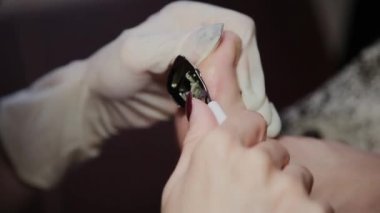 Bakım kız bacaklar pedikür, Lehçe, güzel ışıklar hakkında. Pedikür salonda. Asıl çivi ve istemcinin pedikür yapıyor, ayaklar için umursamıyor. Peeling ayak pedikür yordamı