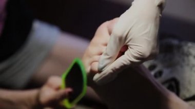 Bakım kız bacaklar pedikür, Lehçe, güzel ışıklar hakkında. Pedikür salonda. Asıl çivi ve istemcinin pedikür yapıyor, ayaklar için umursamıyor. Peeling ayak pedikür yordamı