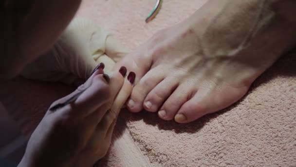 Caring about the girl legs pedicure, polish, beautiful lights. Pedicures in the salon. The master cares for the nails and feet of the client, doing the pedicure. Peeling feet pedicure procedure — Stock Video