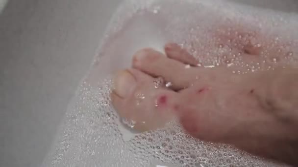 Kvinnan tvättar fötterna i tvålvatten. — Stockvideo