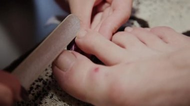 Bakım kız bacaklar pedikür, Lehçe, güzel ışıklar hakkında. Pedikür salonda. Asıl çivi ve istemcinin pedikür yapıyor, ayaklar için umursamıyor. Peeling ayak pedikür yordamı