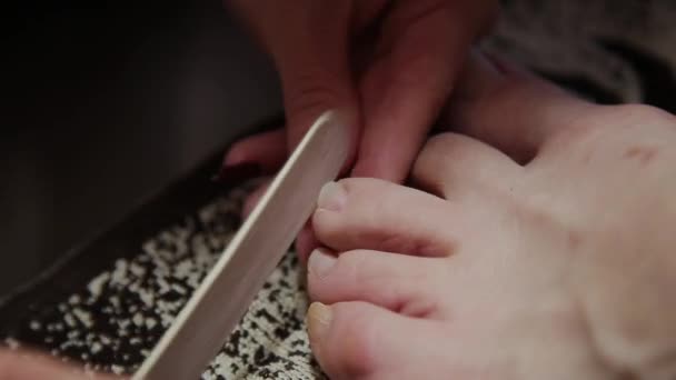 Zorgen te maken over het meisje benen pedicure, Pools, mooie verlichting. Pedicures in de salon. De kapitein zorgt voor de nagels en voeten van de cliënt, doet de pedicure. Peeling voeten pedicure procedure — Stockvideo