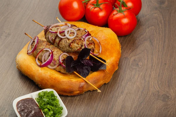 Lulya-kebab. Dönerspieß am Spieß, Hackfleisch. traditionelles kaukasisches Gericht. auf einem Schneidebrett, mit grünem Salat, Ketchup, Gewürzen — Stockfoto