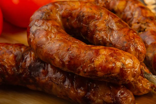 Salsiccia fatta in casa su uno sfondo di legno con condimenti e salsa . — Foto Stock