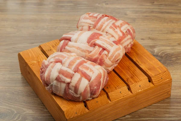 Semi-finished meat, seasoned on a wooden background.