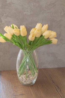 bir tabloda bir vazoda yapay çiçekler.