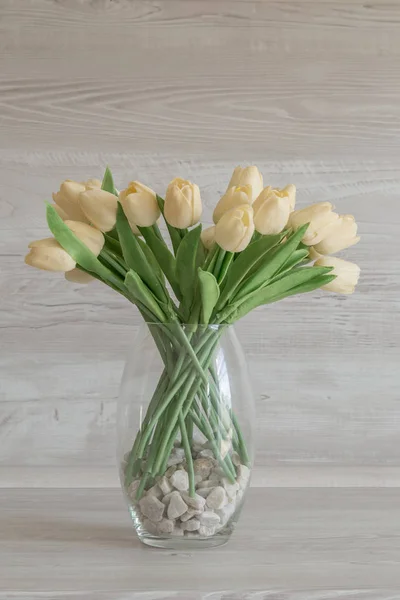 Artificial flowers in a vase on a table.