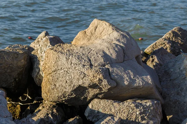 Zee golven strijden tegen de grote rotsen aan de kust. — Stockfoto